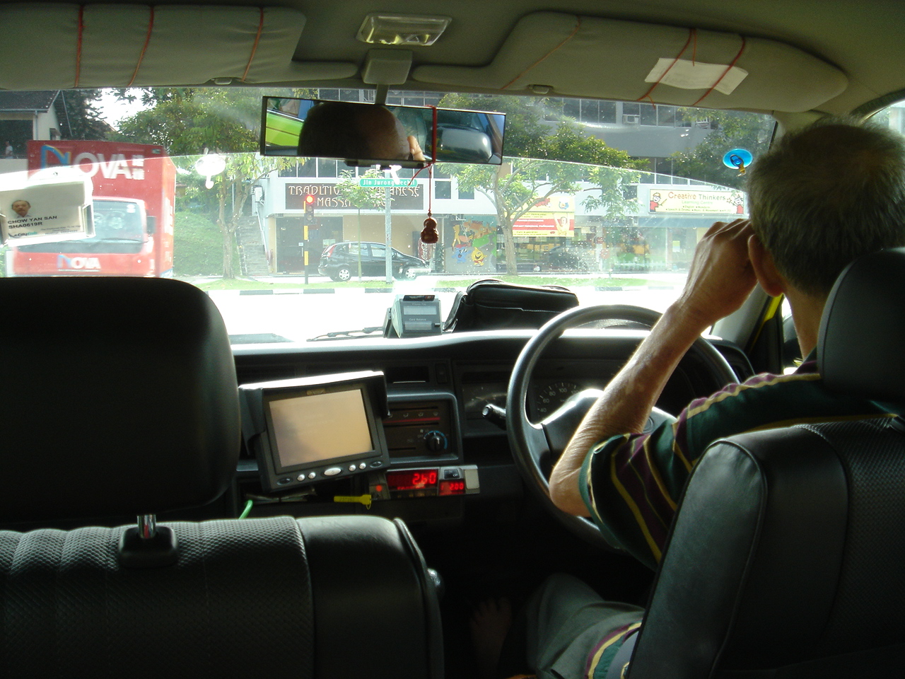 シンガポールのタクシー運転手の特徴 裸足 ちょっとピンボケ かなり大ボケ